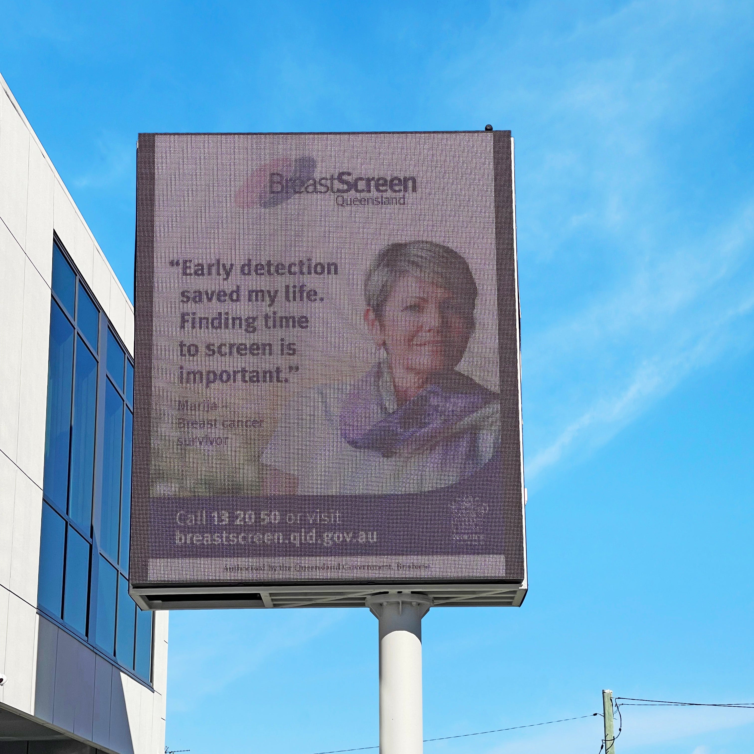 Billboard with a message about breast cancer screening on a clear day.
