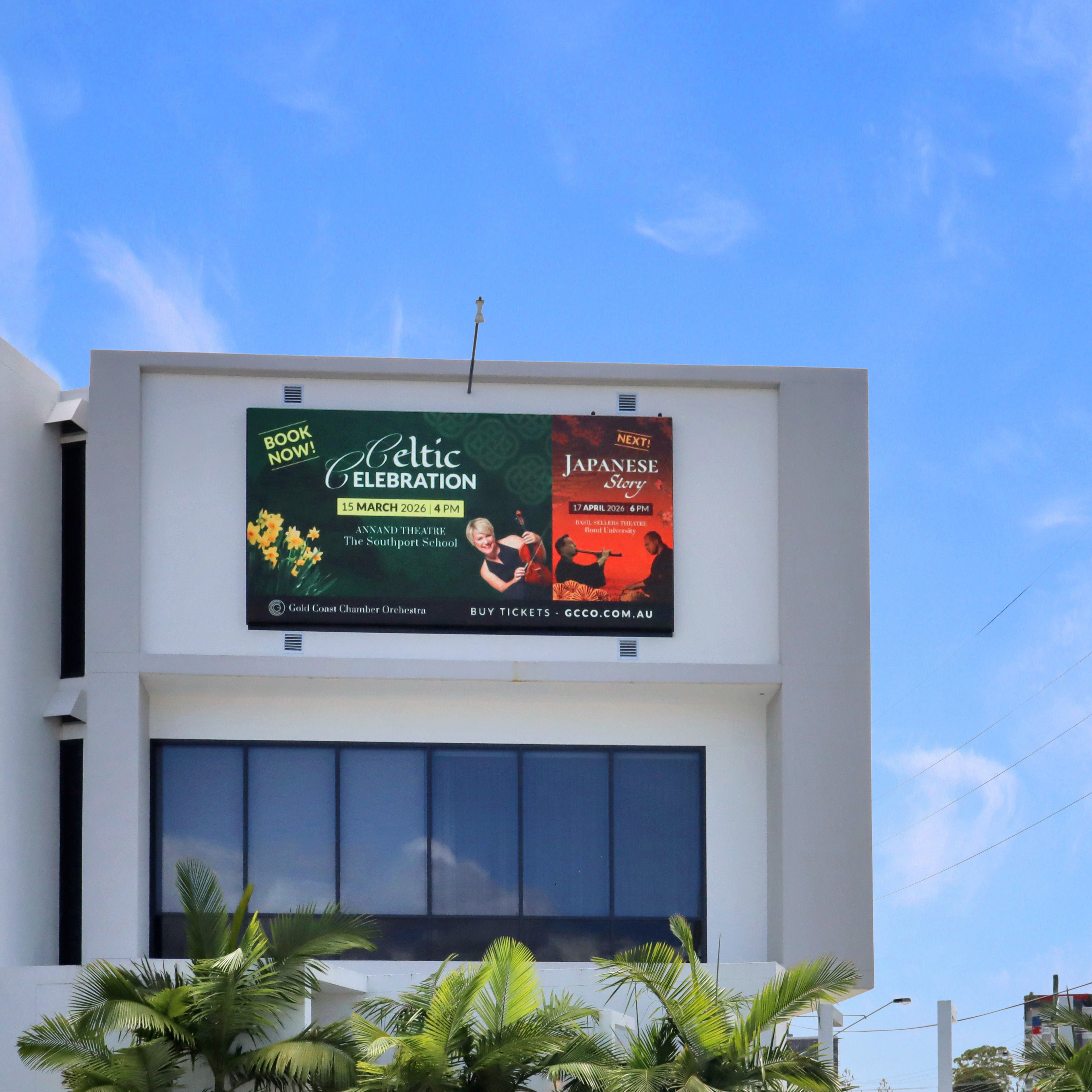 Building exterior with digital billboards displaying advertisements promoting Celtic Celebration and Japanese Story against a blue sky. Bespoke billboard Ferry Road Southport Gold Coast. 