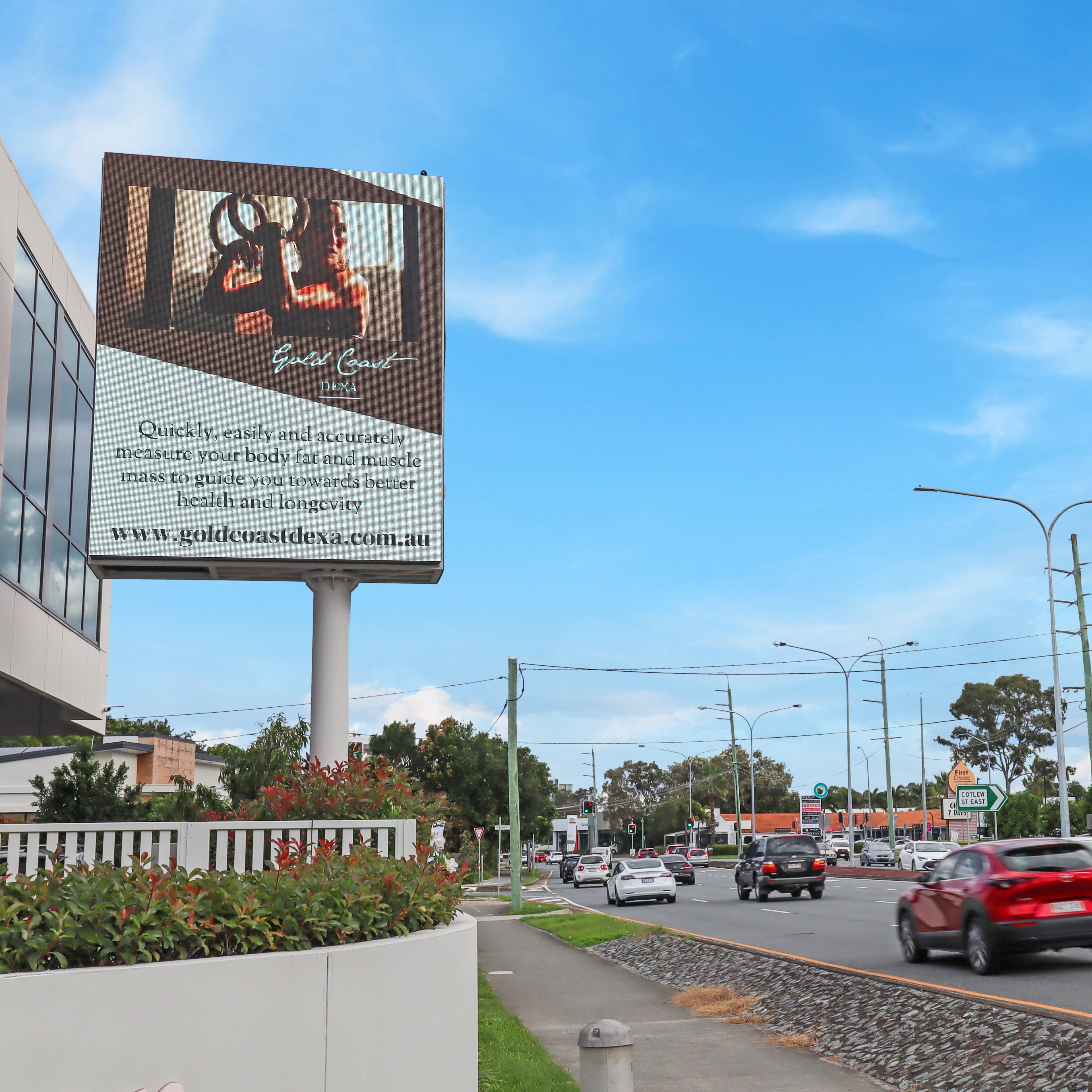 Billboard on a city street with cars and buildings in the background